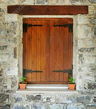 Wooden window in the stone wall