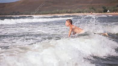Two boys dive into a foaming wave. Live a healthy life. Be H3althy