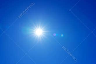 Bright sun with rays and glare in the clear blue sky, sunny cloudless weather