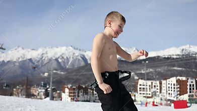 Boy mr dance in trousers on slope near hotels on