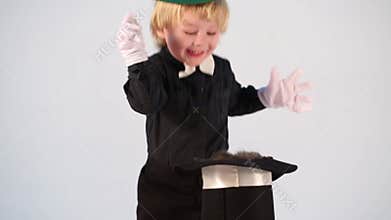 Little boy magician with green cap put kitten in