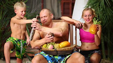 Family of three on a sandy beach near bungalow