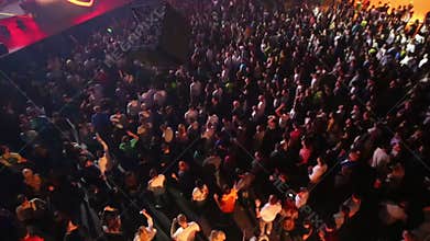 Young people dance during laser show in night
