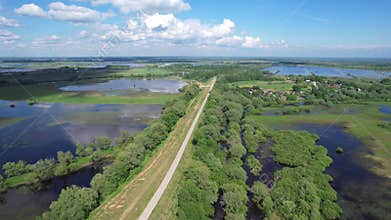 Flying from above over the road flooded fields and meadows