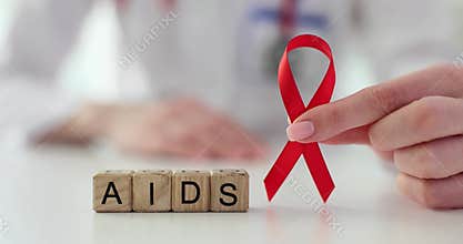 Miniature wooden cubes stand on table forming word AIDS