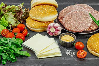 Burger patties. Beef cutlets, buns, vegetables and sauce. Homemade American classic