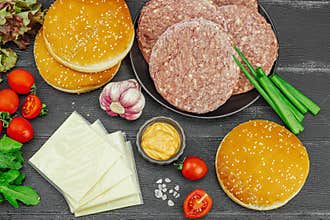 Burger patties. Beef cutlets, buns, vegetables and sauce. Homemade American classic