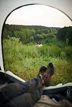 Unrecognizable Tourist Relaxing In Tent