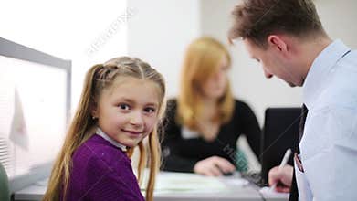 Girl with her father sitting in the office real
