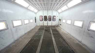 Metal paint-spraying booth with grey walls for