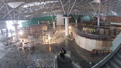 Workers constructing airport terminal, wide view.