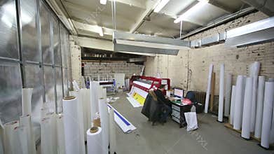 Man works in printing house near the large plotter