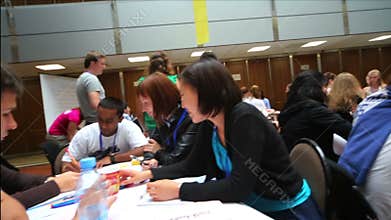 Many young people are sitting at the tables in