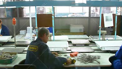 Factory assembly line assembly of electric heaters by hand. Conveyor assembly by hand. Manual assembly conveyor.