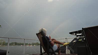 Middle-aged woman drinks cocktail in the sun lounger.