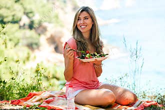 Healthy girl having salad at picnic.