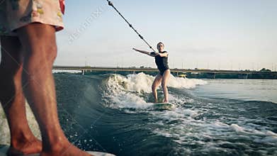 A girl on a wakeboard floats down the river.