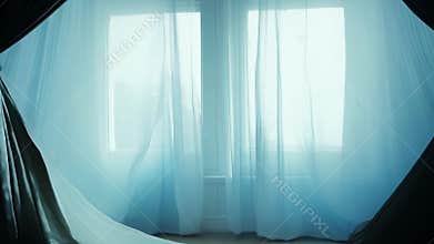 Dark window with curtains blowing in the wind on halloween night