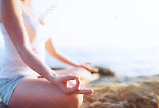 Hand of woman meditating in a yoga pose on beach