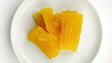 Top view of cassava in syrup in white ceramic dish.