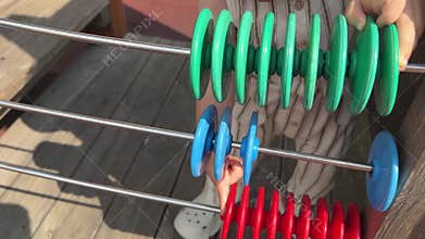 A little child calculates math on a colored abacus, while playing on the playground.