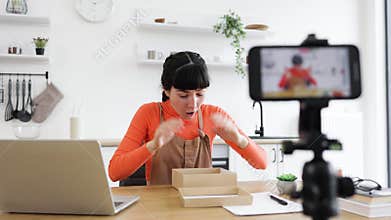 Excited female vlogger unboxing a new smartphone model online