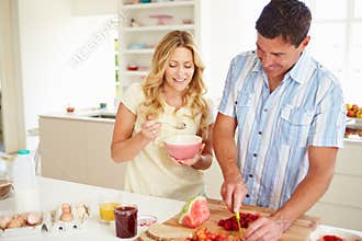 Couple Preparing Healthy Breakfast In Kitchen