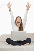 Woman shouting in excitement while working on a laptop