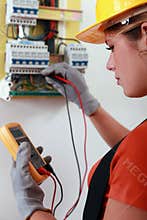 Female electrician checking fusebox