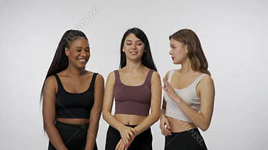 Portrait of young multiethnic models on white studio background close up. Group of three appealing multiracial girls