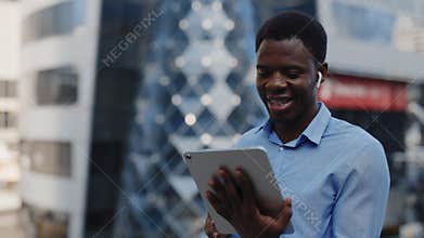 Happy African American Man Holds a Tablet in His Hands and Talks to His Family Via Video Call.