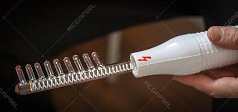 Close up shot of the high frequency comb tool for hair and scalp treatment. Healthcare