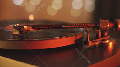 A vinyl record spins in the modern gramophone music player and plays an old disco. Close-up shot of custom vinyl