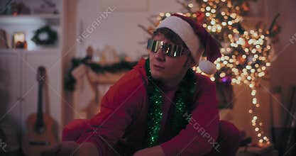 Excited man singing while crouching at illuminated home during Christmas