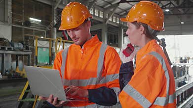 Young caucasian engineer man and woman checking train with laptop in station.
