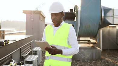 Craftsman standing and looking at wireless tablet outdoors
