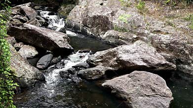 A set of cascades flowing between rocks in a creek bed