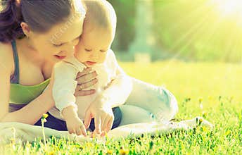 Happy family. Mom and baby in a meadow in the summer in the park