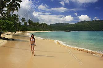 Young woman in bikini walking at Rincon beach, Samana peninsula