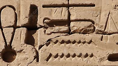 Ancient Egyptian hieroglyphs and bas-reliefs close-up in Temple of Medinet Habu. Egypt, Luxor. The Mortuary Temple of