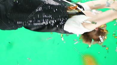 Happy young man jumping dancing throws sparkling confetti.