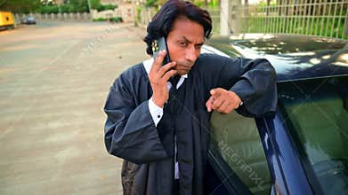 Lawyer talking on mobile by car