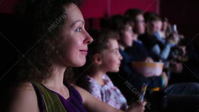 A woman watching a movie in a theater with