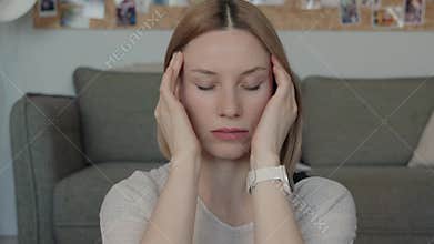 Woman with eyes closed in deep thought or stress at home