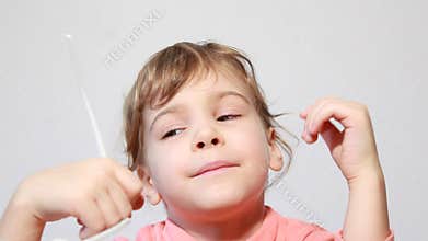Little girl play with white shutter shades
