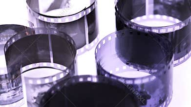 rolls of black and white negative film revolve on