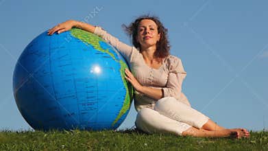 cute girl sits relaxing in grass and rests on