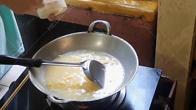 Adding a spoonful of salt and a spoonful of MSG into mixed egg or beaten egg or whisked egg in the frying pan