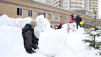 Little boy is constructing the snow fort at