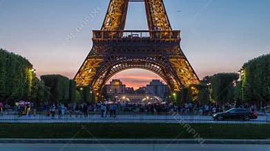 Eiffel Tower day to night timelapse and people sitting on the grass in the evening in Paris, France
